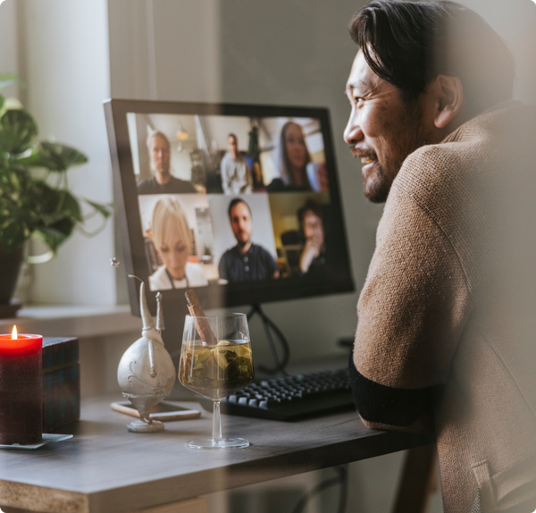 Person sitting at a desk with a zoom meeting shown on his computer screen